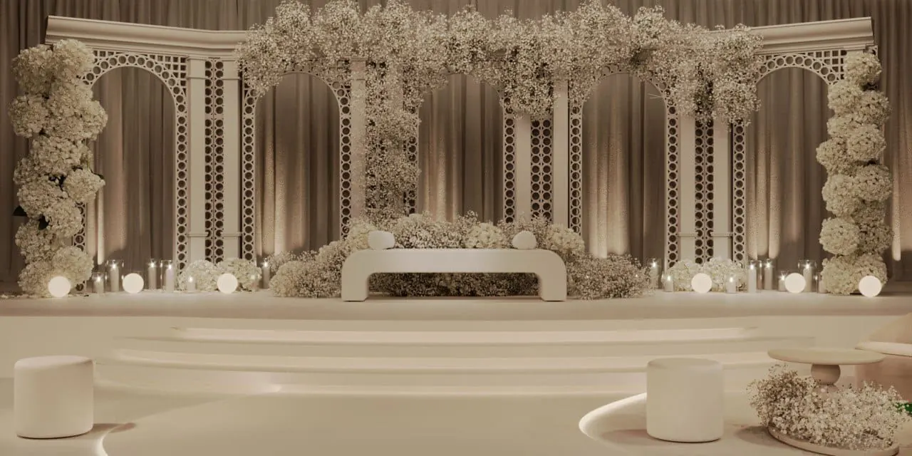 Ivory wedding stage with floral arches and candlelight by RAW Group